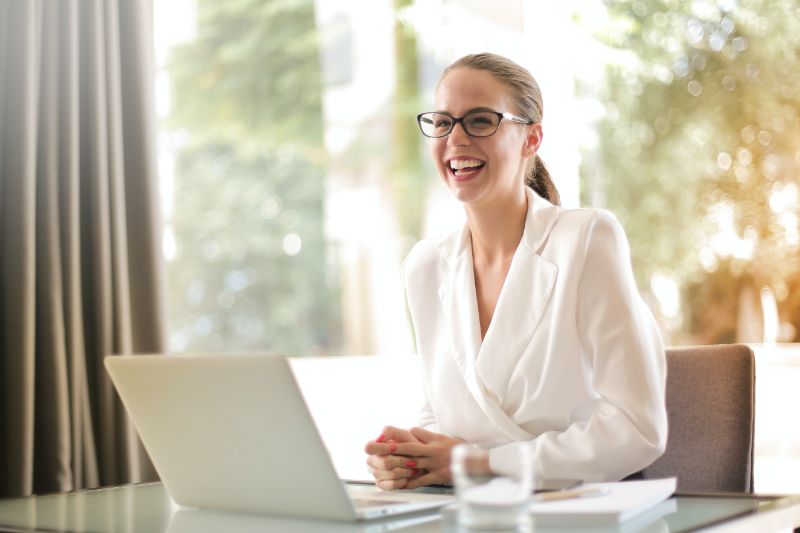 a smiling person with her laptop