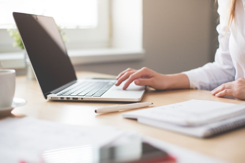 A person with a laptop and paperwork