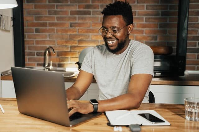 a person sitting and working on the laptop placed on the table