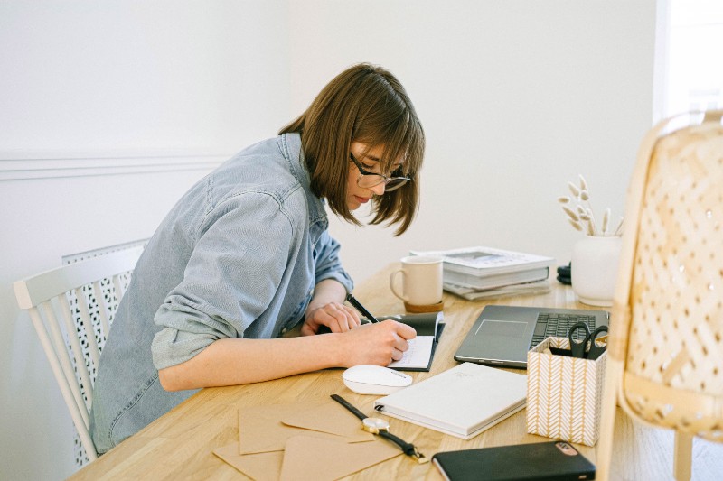 A woman blogging with a notebook on a desk