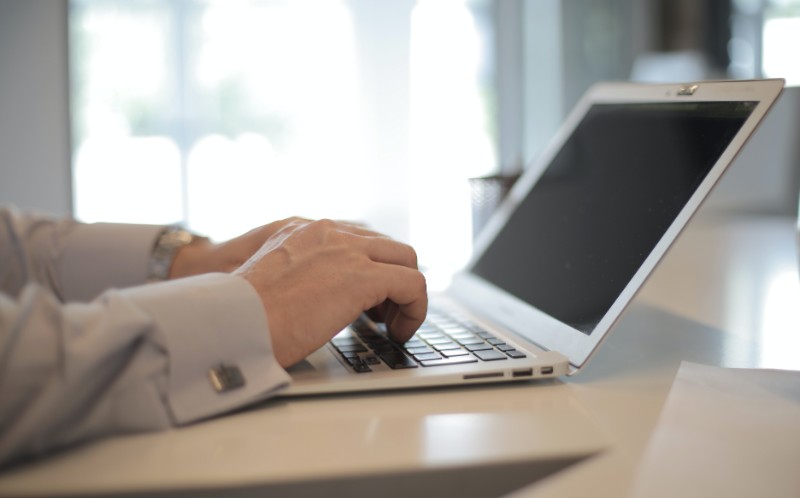 a-man-using-laptop-computer-on-white-table