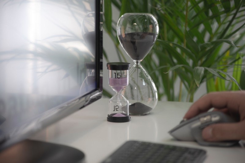 Two hourglasses beside a computer, time management