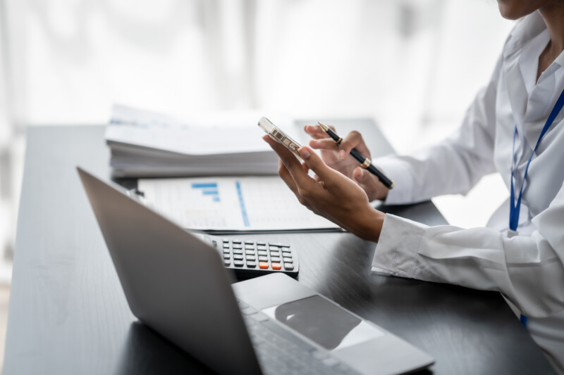 Female accountant with a laptop, phone, and calculator