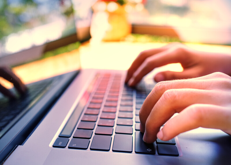 Hand typing on a laptop