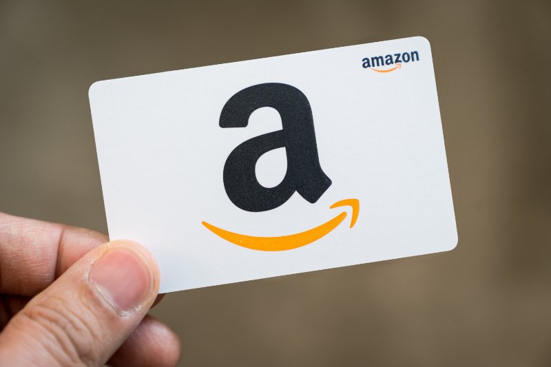 Hand holding an Amazon gift card