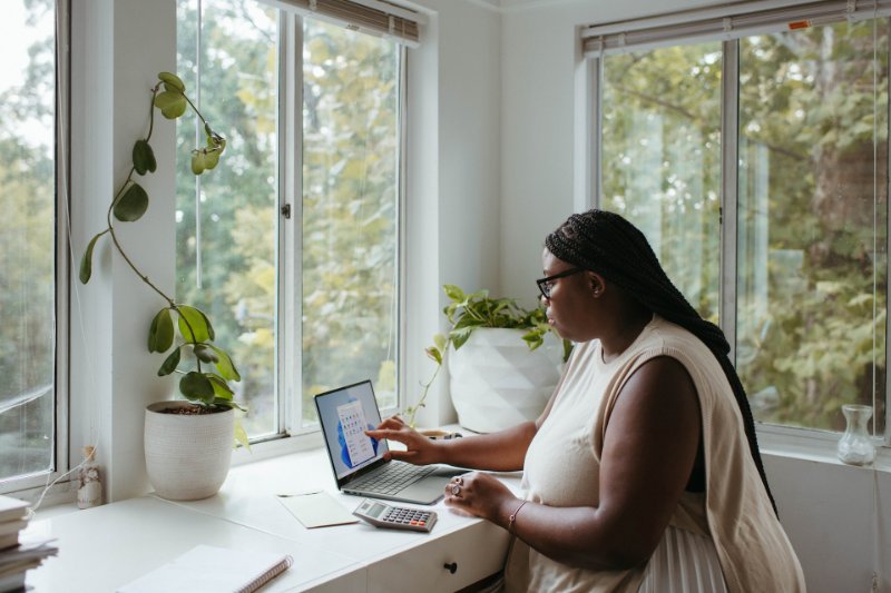 a woman using her laptop on the table with a calculator