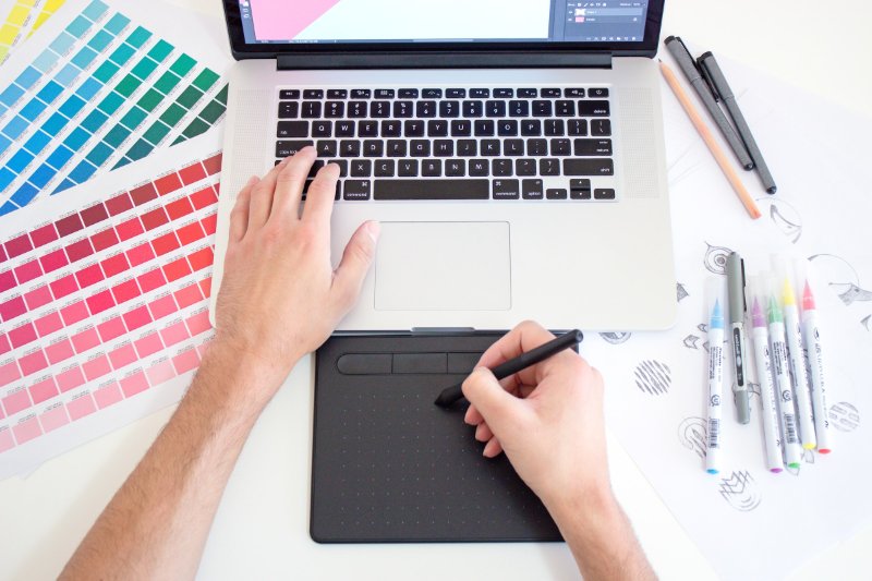 A man using the laptop with a pen in his right hand