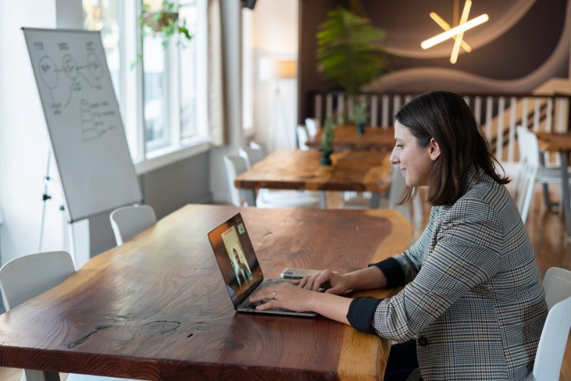 A woman talking to someone through her laptop