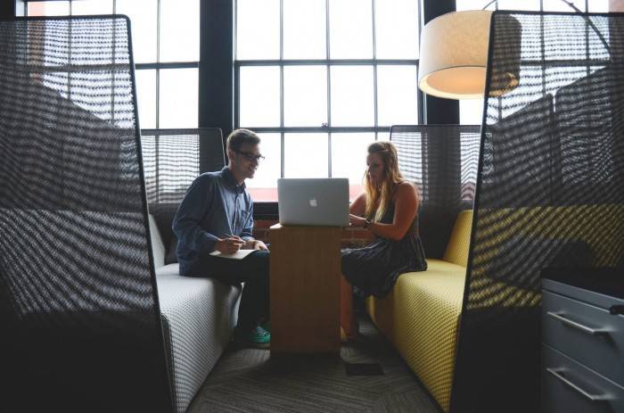 A man and woman looking at laptop and discussing something