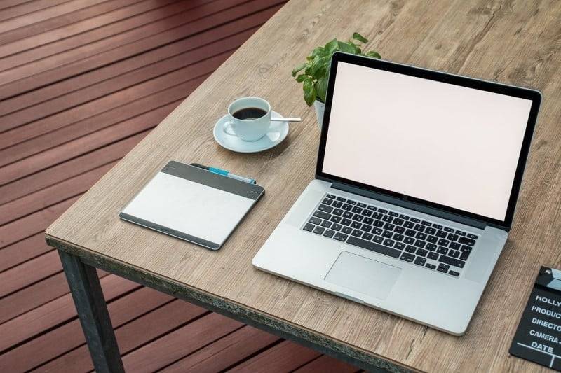 Laptop and graphics design tablet on wooden table