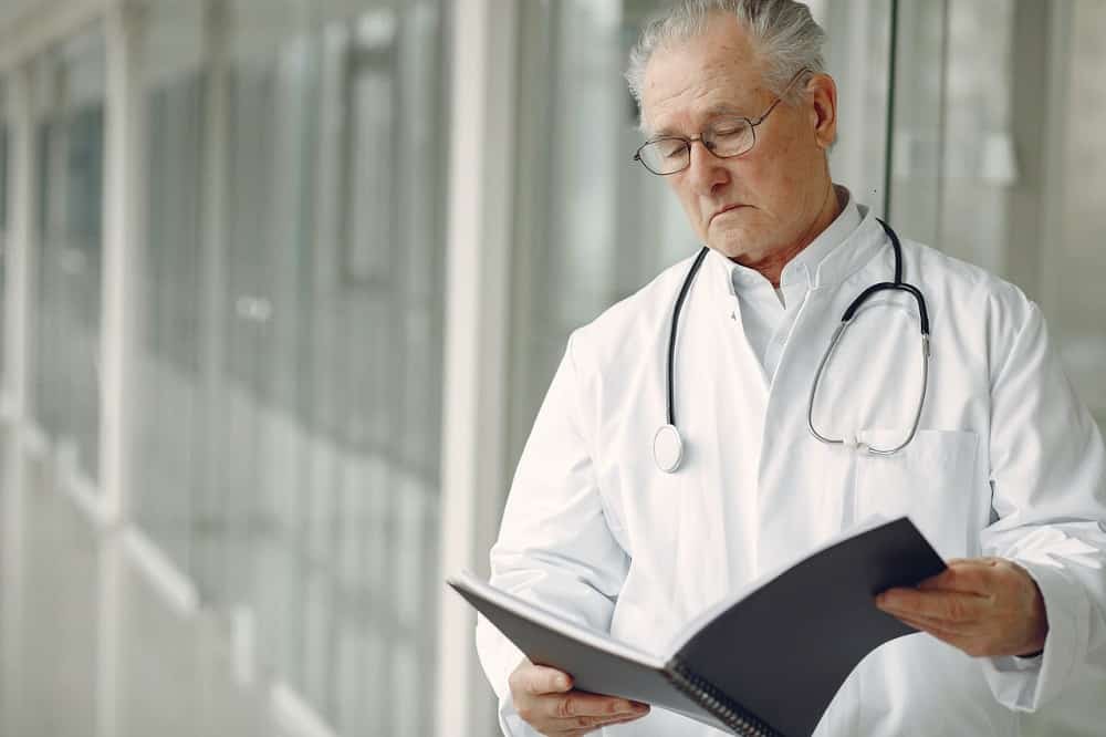 medical pofessional with a stethoscope reading a report