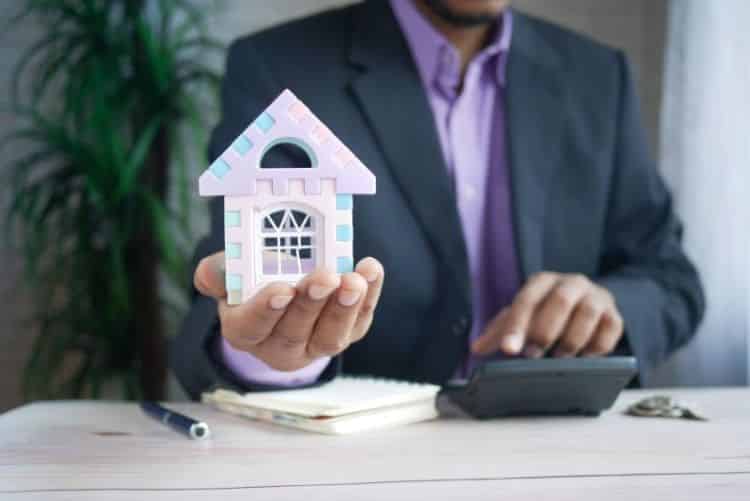 Man holding a tiny house