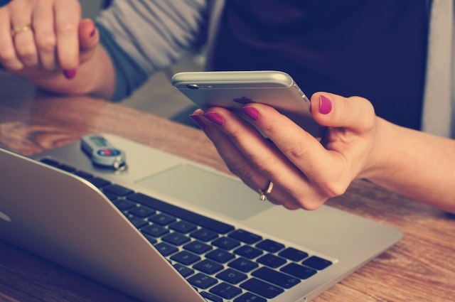 A girl using her phone and laptop