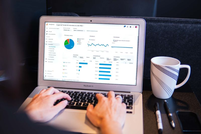 A man creating market research graphs on a laptop