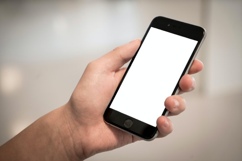 Person Holding Iphone Displaying White Screen