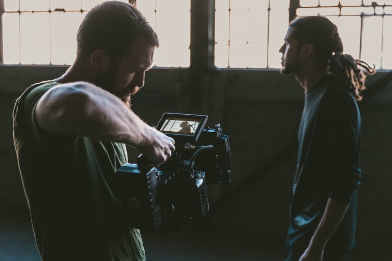 man holding a camera and fimling an actor