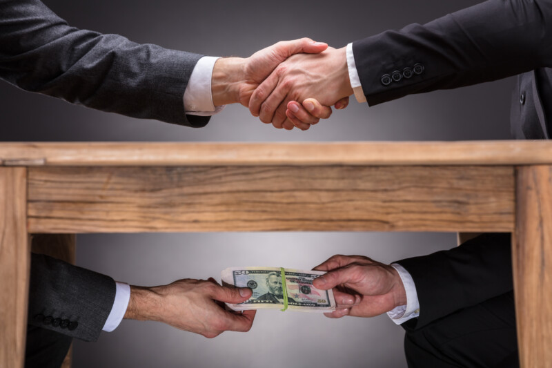 Tow businessman doing a under the table transaction