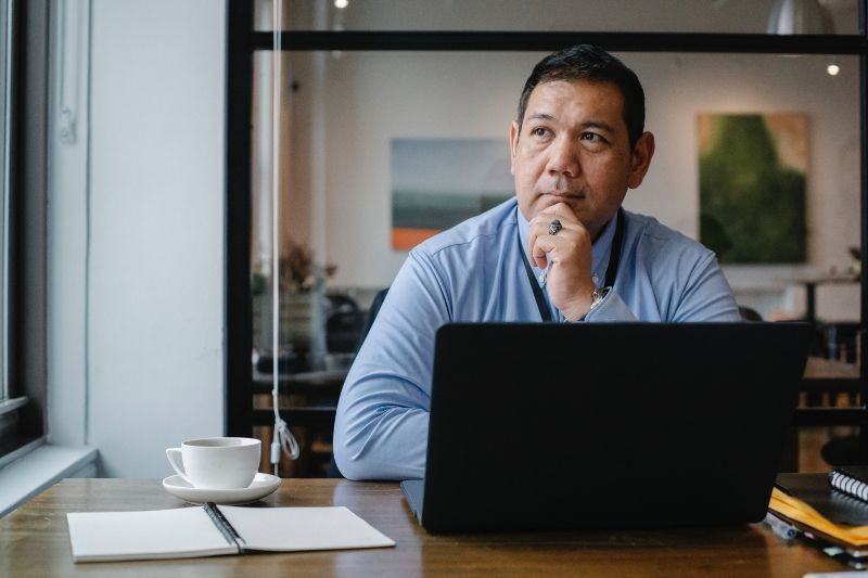 A man in an office holding his chin