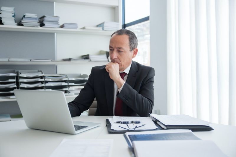 A man in an office looking at his laptop