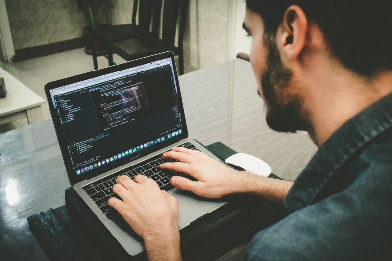 Man programming using his  laptop