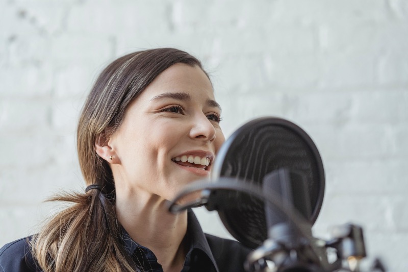 Woman recording voice on microphone