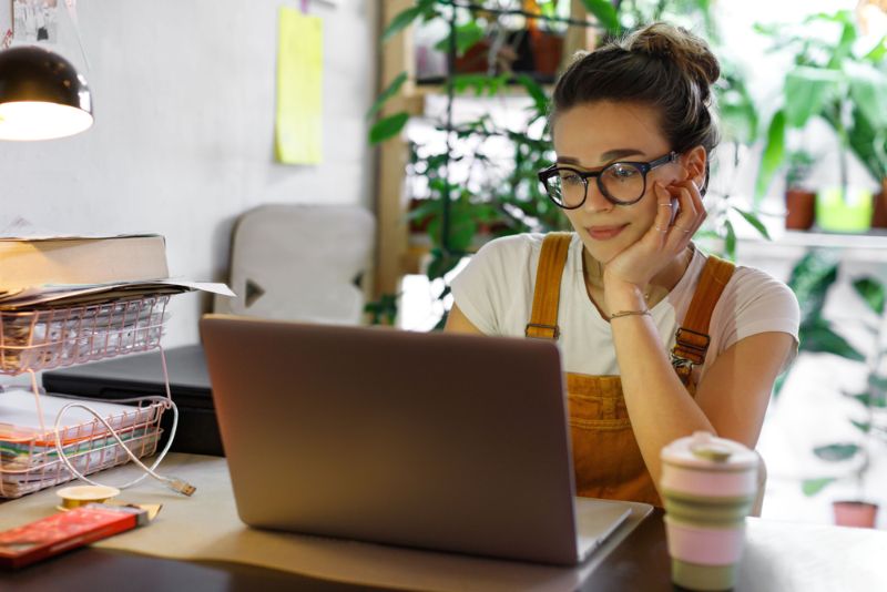 Young woman in glasses using laptop