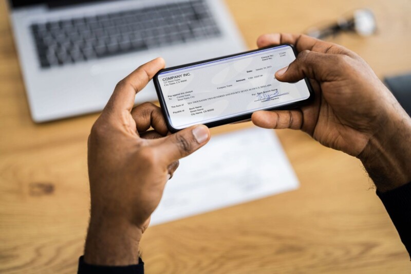 A person taking a picture of his check