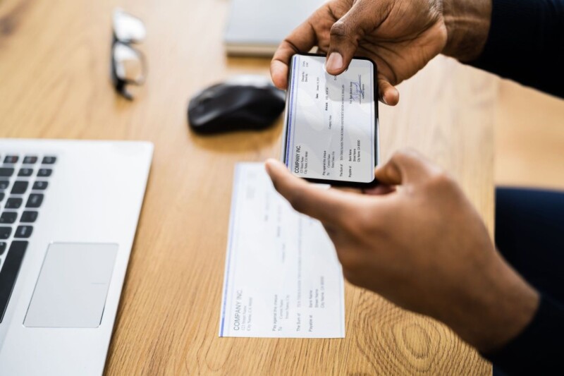 A person taking a photo of his check