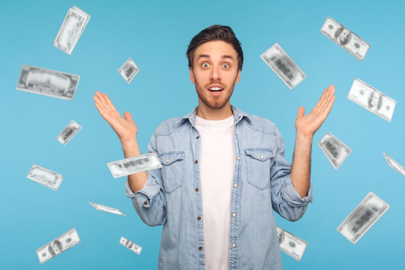 Amazed man absolutely shocked of money falling down