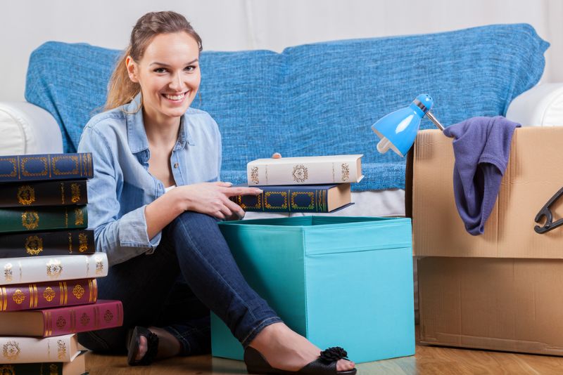 Smiling woman packing books for rental