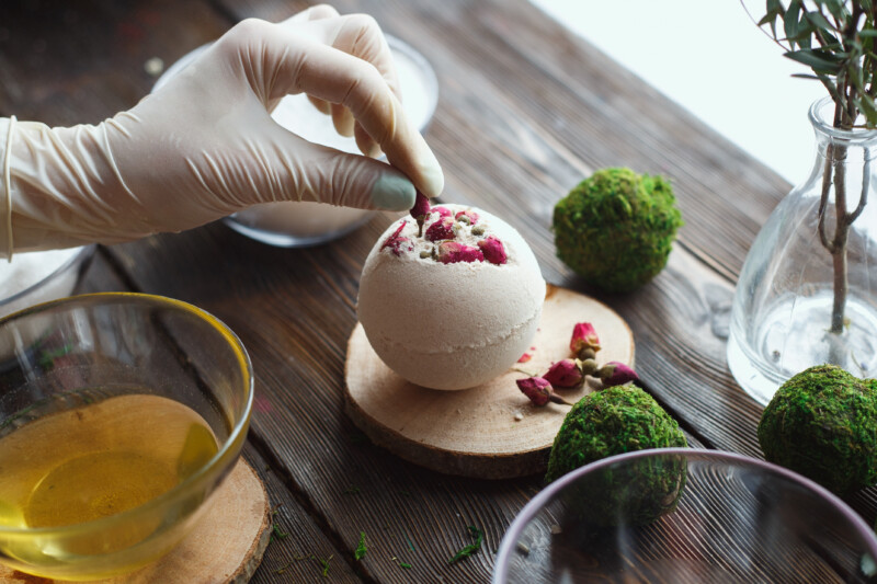 Preparation of bath bombs. Ingredients and floral decor on a wooden vintage table