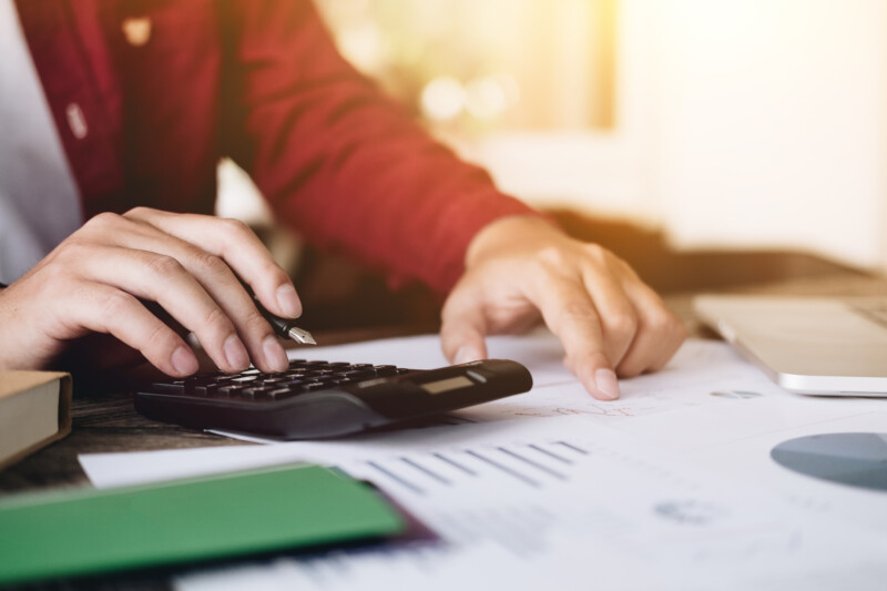 Close up view of bookkeeper or financial inspector hands making report, calculating or checking balance