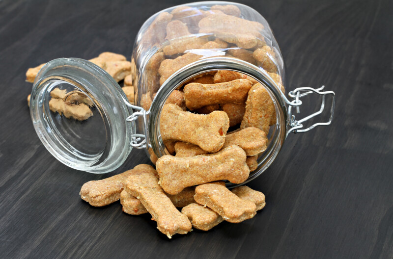 Homemade dog bones spilling from a glass jar.
