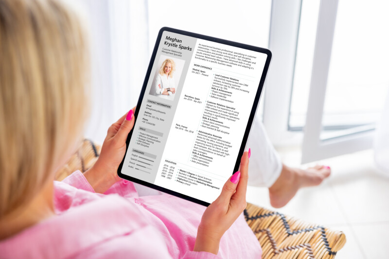 Woman looking at her CV document on tablet computer to apply for a new job