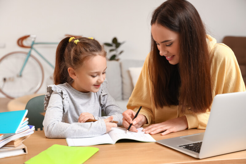 Cute girl studying with tutor at home
