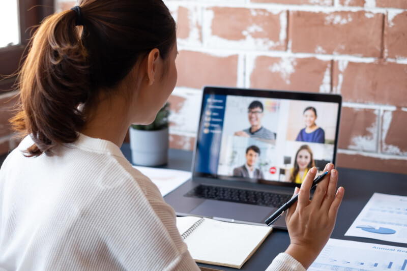 Young Asian businesswoman work at home and virtual video conference meeting with colleagues business people