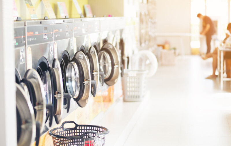 Row of industrial laundry machines in laundromat