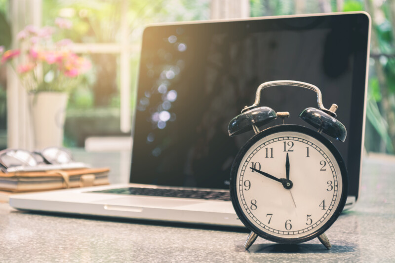 Alarm clock with laptop in the background