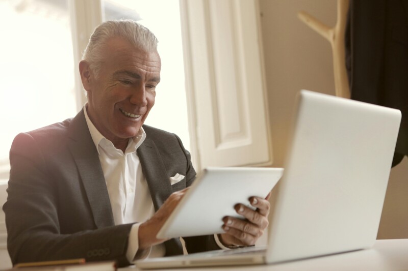 An aged man working on a Laptop