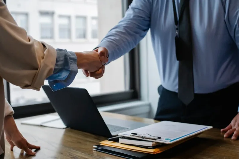 colleagues shaking hands in office
