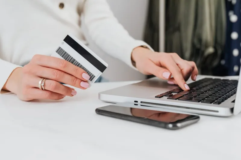 Person Using a Laptop and Holding a Credit card