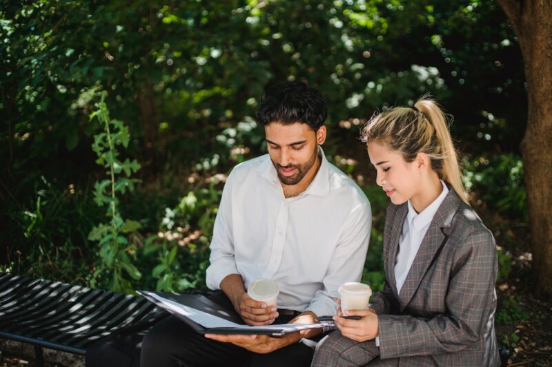 People Discussing Business While Sitting Outside with a Cup of Coffee