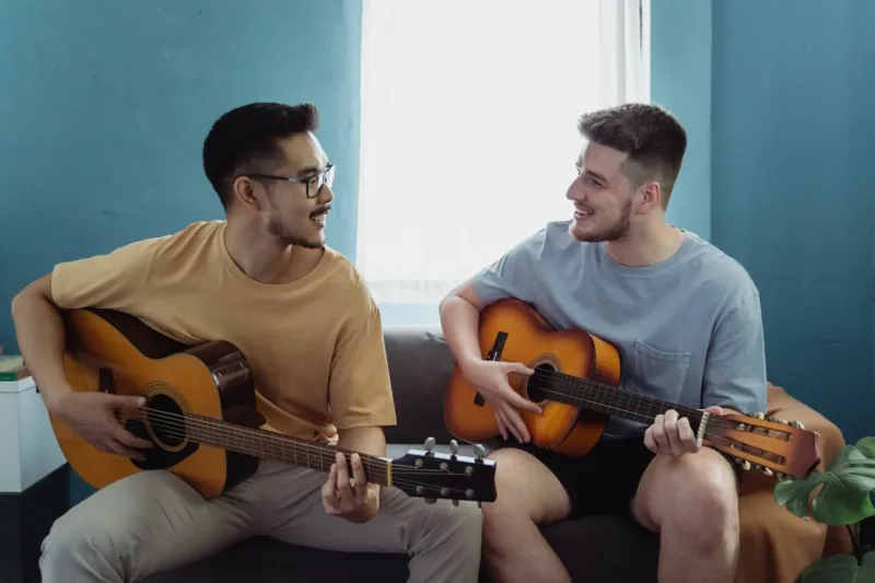 Men Playing the Guitars and Smiling