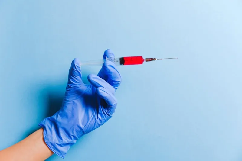 A person holding syringe used for blood donation